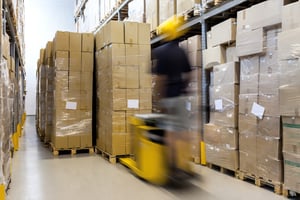 Fork lift with operator working in warehouse