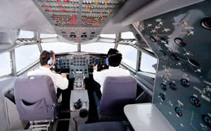 Pilots inside a cabin flying an airplane